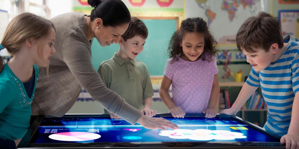 Niños interactuando con pantalla digital