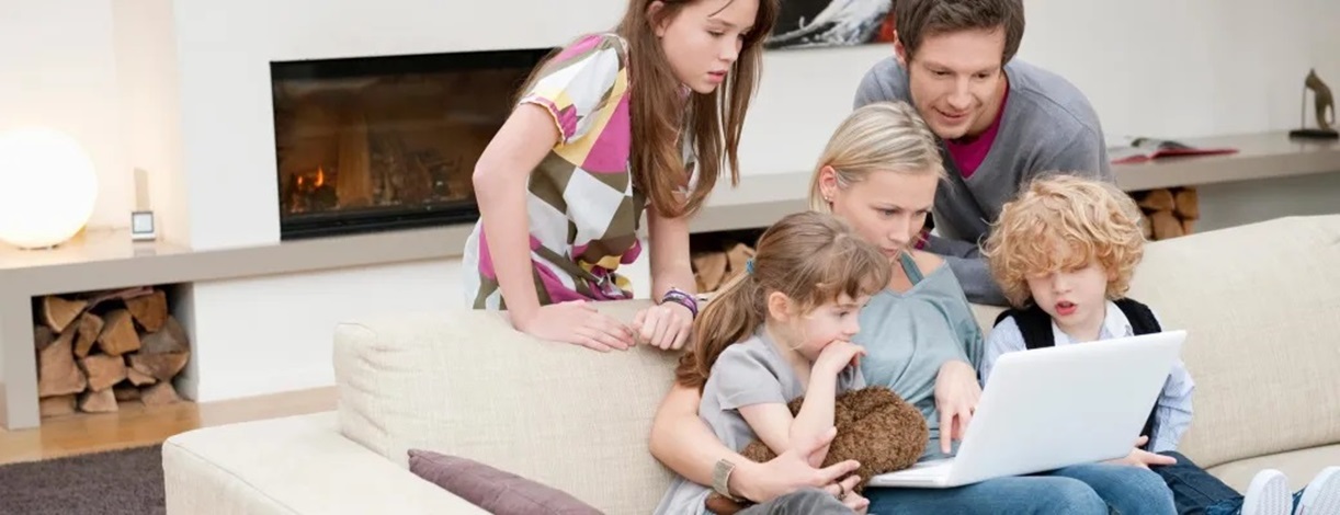 Familia en un salón mirando un portátil
